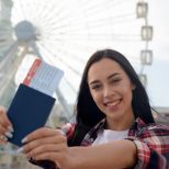 portrait-smiling-woman-showing-air-ticket-passport
